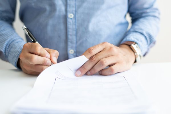 Closeup of business man signing document