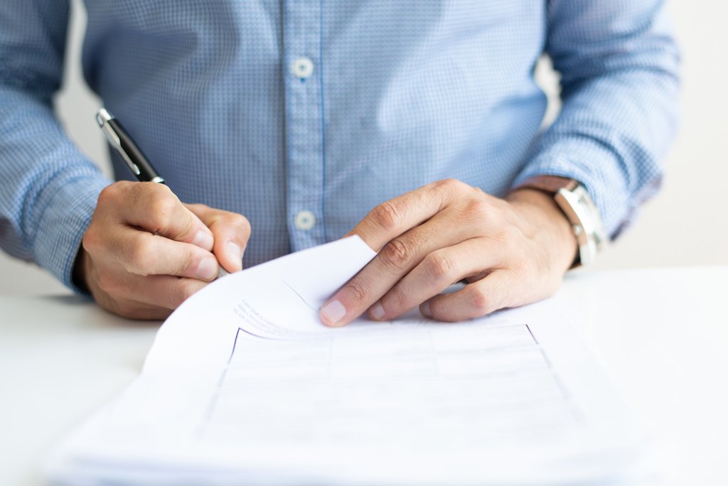 Closeup of business man signing document